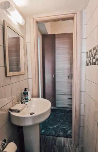 a bathroom with a sink and a shower at Efrosini downtown apartment in Chalkida