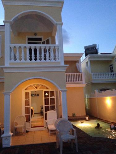 a house with a balcony and a swimming pool at Villa Pereybere #2 in Pereybere