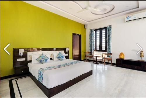 a bedroom with a bed and a yellow wall at ZEST DAMODAR GARH - The Stress Free Zone in Jodhpur