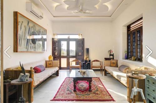a living room with a couch and a table at ZEST DAMODAR GARH - The Stress Free Zone in Jodhpur