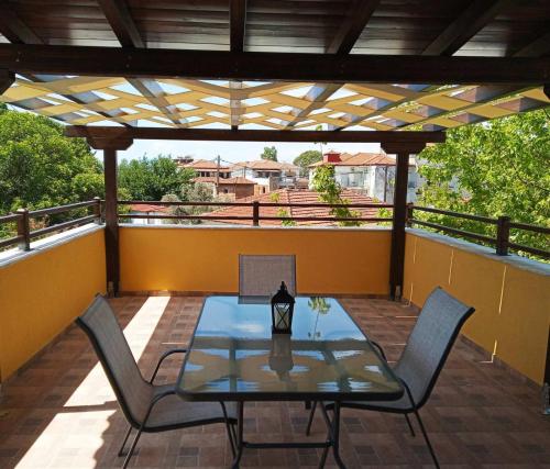 a patio with a table and chairs on a balcony at Vasileiou in Kala Nera