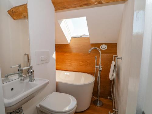 a small bathroom with a toilet and a sink at The Barn at Chatsworth Farm in Leek