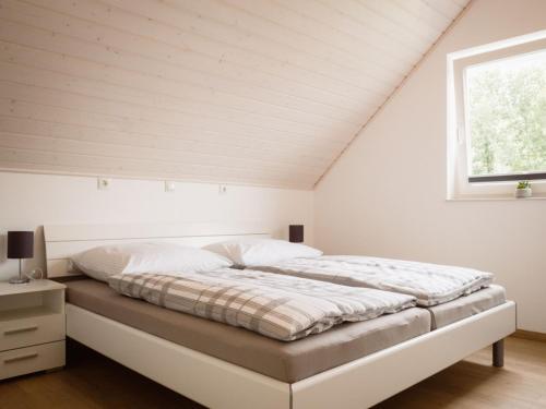 a white bedroom with a bed in a attic at Vechtestrand - Nordhorn in Nordhorn