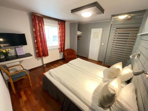 a bedroom with a large white bed and a window at Davids Kulle in Ronneby