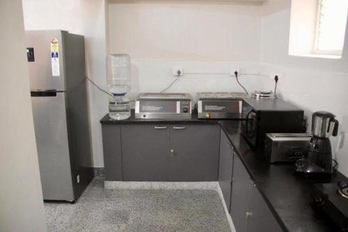 a kitchen with a refrigerator and a counter top at Habitat15@airlines in Bengaluru