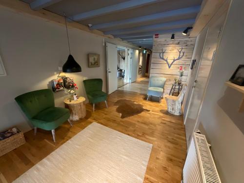 a living room with two green chairs and a table at Davids Kulle in Ronneby
