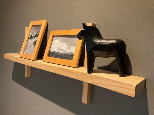 a shelf with two pictures and a statue of a horse at Davids Kulle in Ronneby