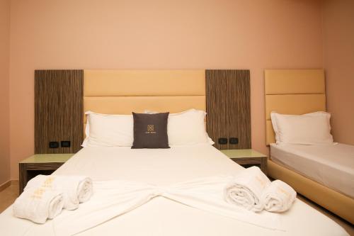 a bedroom with a bed with towels on it at Aliko Hotel in Vlorë