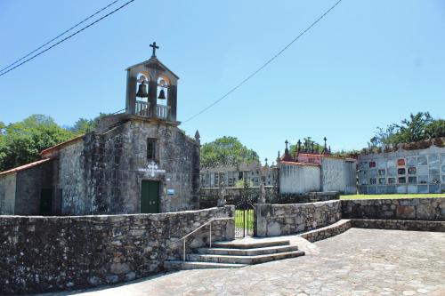 an old stone building with a bell tower and stairs at Albergue Rectoral San Mamede da Pena EXCLUSIVE FOR PILGRIMS in Negreira