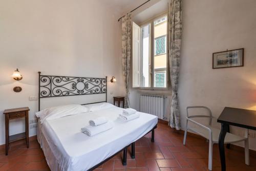 a bedroom with a bed and a table and a window at Casa Ghibellina by Mmega in Florence