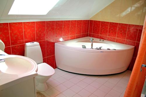 een badkamer met een bad, een toilet en een wastafel bij Rivaal Guesthouse-Cafe in Põltsamaa