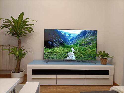 una sala de estar con TV en una cómoda blanca en Apt. Descenso del Sella, Arriondas, en Arriondas