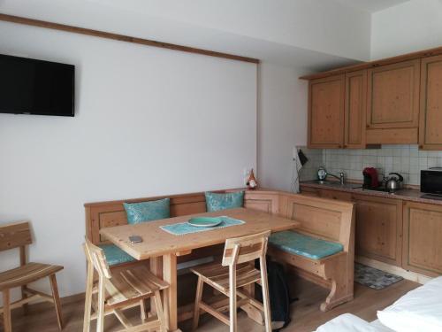 a small kitchen with a wooden table and chairs at La Casa degli Gnomi in Falcade