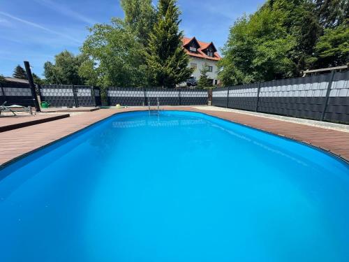 een groot blauw zwembad in een achtertuin met een hek bij Ennerla Hof in Pottenstein