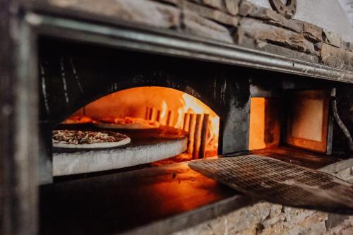 a brick oven with two pizzas in it at Martinerhof's Brauhotel in San Martino