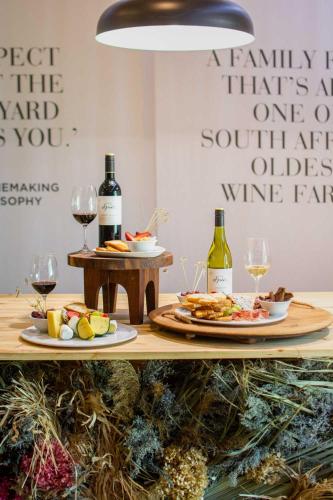 a table with two plates of food and wine glasses at Indaba Hotel, Spa & Conference Center in Johannesburg