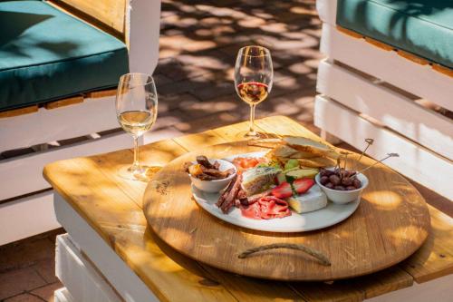 a plate of food on a table with two glasses of wine at Indaba Hotel, Spa & Conference Center in Johannesburg