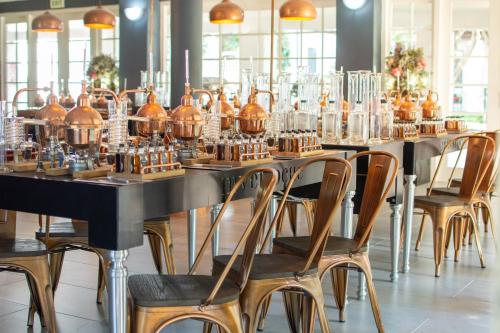 a row of tables and chairs with glass vases at Indaba Hotel, Spa & Conference Center in Johannesburg