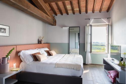 a bedroom with a large bed and a window at Laqua Vineyard in Terricciola