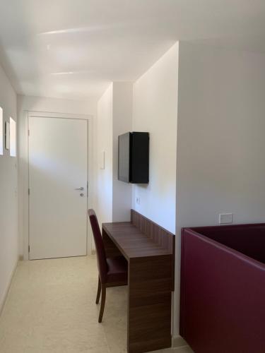 a room with a desk and a tv on a wall at Agriturismo Ca' Verde in SantʼAmbrogio di Valpolicella
