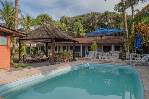 a swimming pool in front of a house at Residencial Solar do Pescador in São Sebastião
