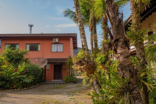 a house with palm trees in front of it at Residencial Solar do Pescador in São Sebastião