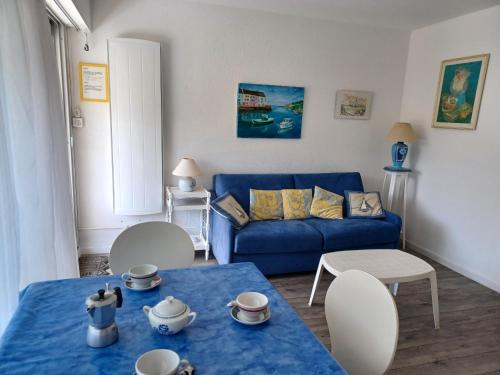 un salon avec un canapé bleu et une table bleue dans l'établissement FLEUR DE SEL - Balcon, Thalasso 50m - UD101, à Carnac