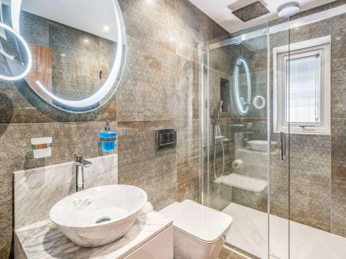 a bathroom with a sink and a glass shower at Haven Cottage in Blackburn