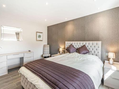 a bedroom with a large bed and a desk at Haven Cottage in Blackburn