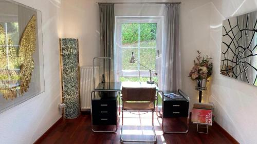 ein Wohnzimmer mit einem Stuhl und einem Fenster in der Unterkunft Exklusive Ferienwohnungen und Business Apartments Marburg in Marburg an der Lahn