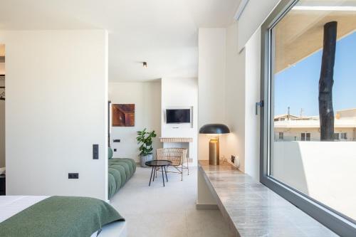 a bedroom with white walls and a large window at Aristea Hotel in Rethymno Town