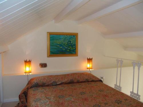 a bedroom with a bed and a painting on the wall at Casa di Ida in Locri