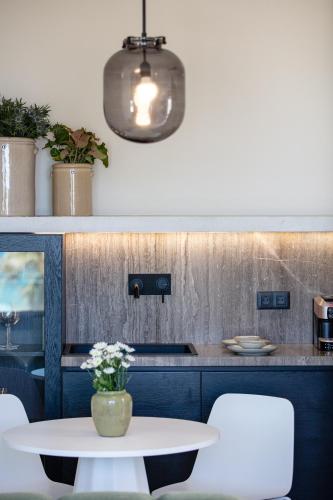 a kitchen with a table and a light fixture at Aristea Hotel in Rethymno Town
