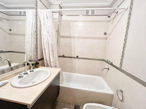 a bathroom with a sink and a bath tub at Constantino Iii in Villa Carlos Paz