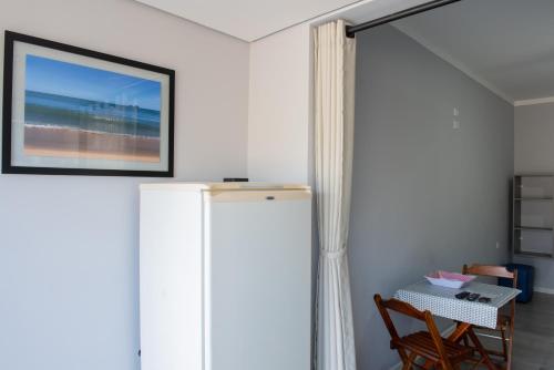 a room with a table and a picture on the wall at Residencial Solar do Pescador in São Sebastião