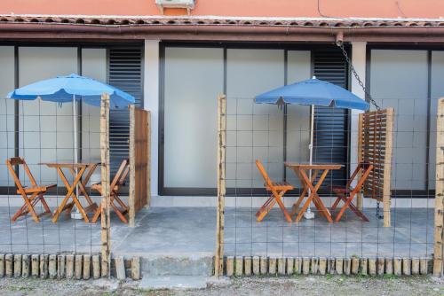 two tables and chairs with umbrellas in front of a building at Residencial Solar do Pescador in São Sebastião