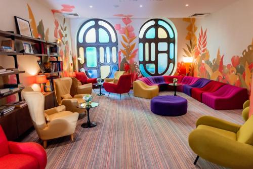 a waiting room with colorful furniture and windows at La Residence Du Vieux Port in Marseille