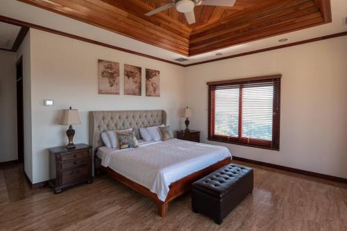 a bedroom with a bed and a ceiling fan at Casa Amarillo Jaco Beach Costa Rica in Jacó
