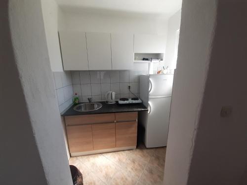 a small kitchen with a sink and a refrigerator at Apartman Emanuel in Jajce
