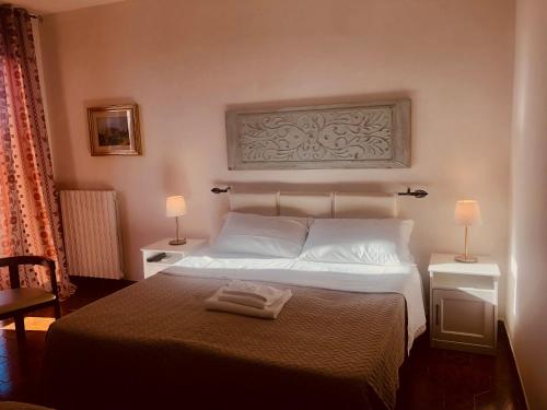ロッカ・サン・ジョヴァンニにあるMA.DI BBのベッドルーム1室(白いベッド1台、テーブル2台、ランプ2つ付)