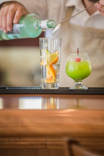 a person is pouring a drink into a glass at Kefalonia Bay Palace in Kefallonia