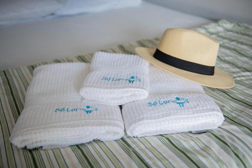 two towels with a hat on a bed at Residencial Solar do Pescador in São Sebastião