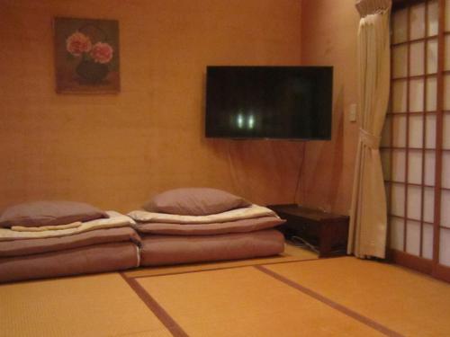 a room with two beds and a flat screen tv at Minato Oasis Numazu / 沼津観光の中心、伊豆観光の拠点に好立地！沼津港に位置し交通・飲食・コンビニ等至便です！ in Numazu