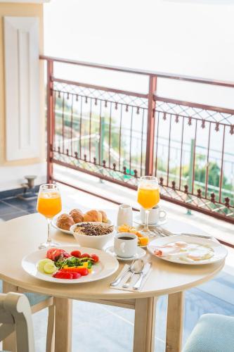 a table with two plates of food and two glasses of orange juice at Kefalonia Bay Palace in Kefallonia