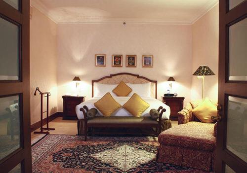 a bedroom with a bed and a couch and a chair at Dorsett Grand Labuan in Labuan