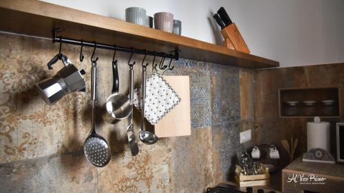 a kitchen with utensils hanging on a wall at Al Vico Primo - Boutique Apartment in Pietrapertosa