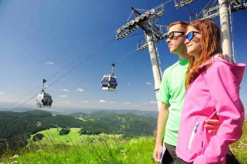 a man and a woman standing in front of a ski lift at Panorama apartmán 44-C in Donovaly