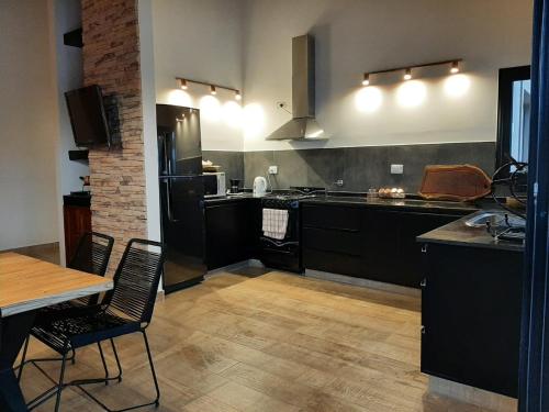 a kitchen with black cabinets and a table and chairs at Casa en Vaqueros in Vaqueros