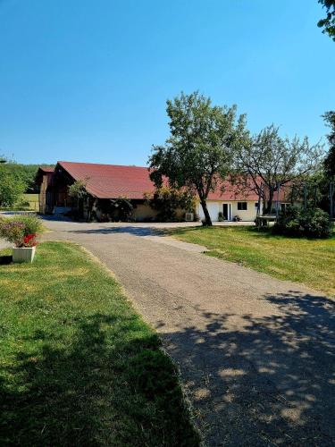 un camino que conduce a una casa con techo rojo en La Favière Enchantée - le gîte, en Cult