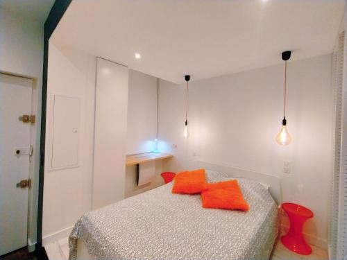 - une chambre dotée d'un lit avec des oreillers orange dans l'établissement Kutxa Belza au coeur de Bayonne, à Bayonne